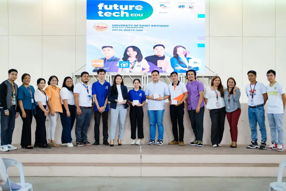 About twenty people lined up on a stage beneath a Future Tech EDU event screen